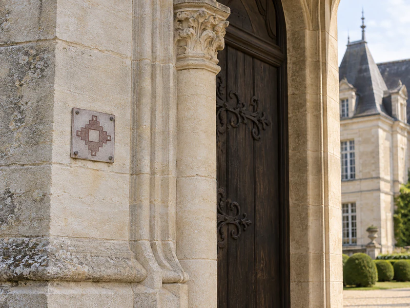 Plaque Monument historique sur un portail de château en pierre de taille