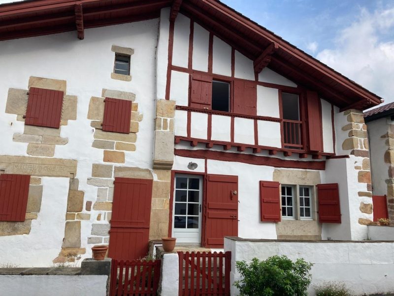Façade de la maison en pierres historiques à Sare présentant des traces de remontées capillaires et d'efflorescences salines traitées par Mur-Tronic