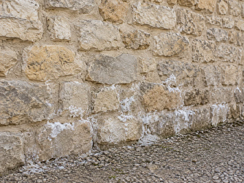 Salpêtre blanc dans les joints à la chaux d'un mur en pierre ancienne