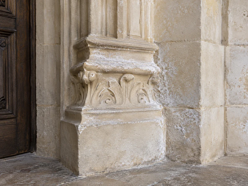 Efflorescences salines sur une moulure de pierre de taille dans un château